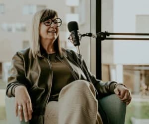 Liesbeth zit aan een micro om een podcast te maken