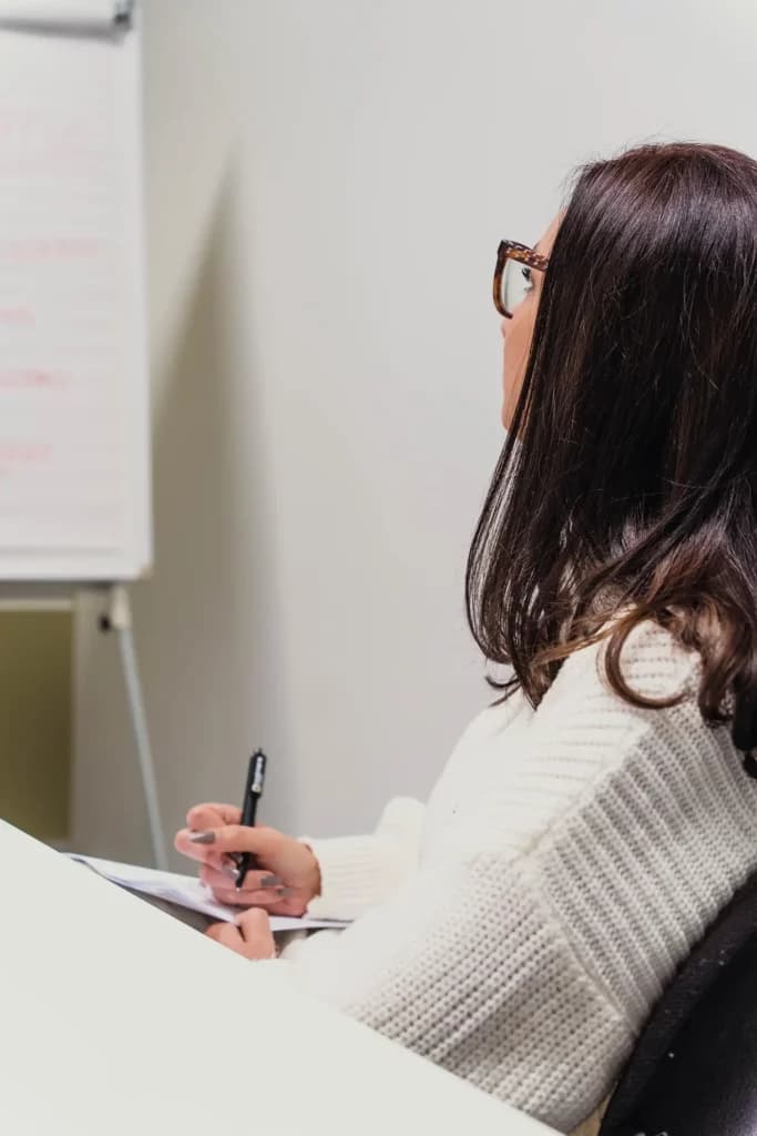 Een medewerker van Motmans is aandachtig aan het luisteren terwijl ze notities neemt